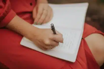Libro abierto sobre mesa de madera junto a fotografía antigua y carta manuscrita bajo luz natural