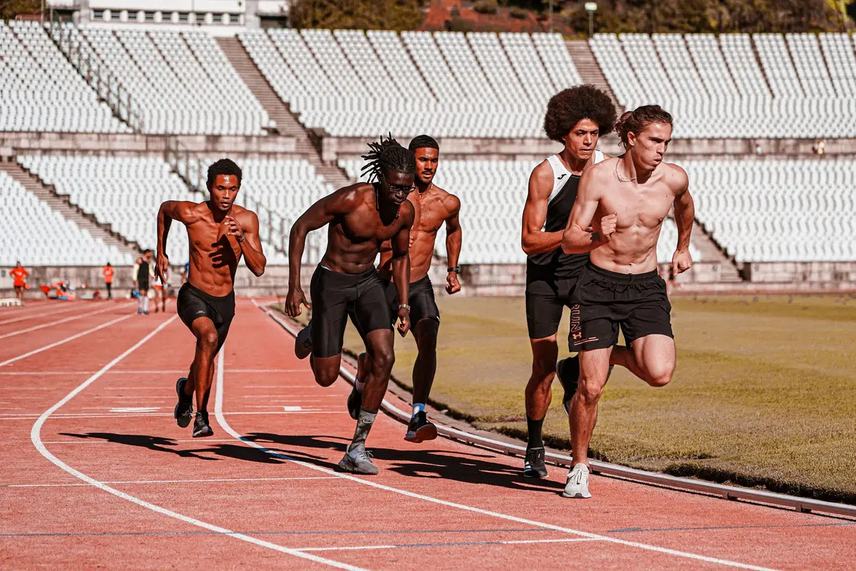 Velocistas en una carrera de relevos en un estadio de atletismo