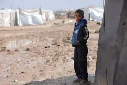 Punto de control fronterizo con personal de seguridad y migrantes en la distancia durante operación humanitaria