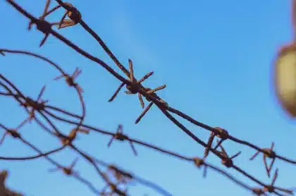 Personas anónimas en un puesto fronterizo con presencia de seguridad, ilustrando la crisis migratoria en Ceuta.
