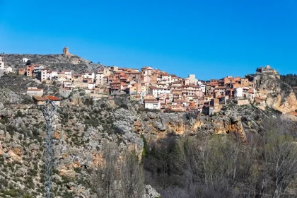 Carretera de montaña con pueblos tradicionales y valles verdes bajo luz dorada