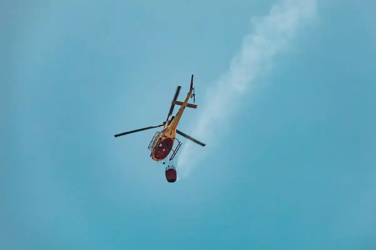 Helic&oacute;ptero de extinci&oacute;n descargando agua sobre el fuego forestal