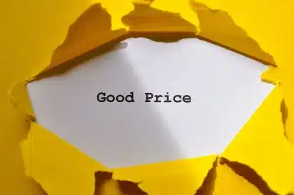 Monedas y etiquetas de precios en estantería de supermercado con flecha descendente