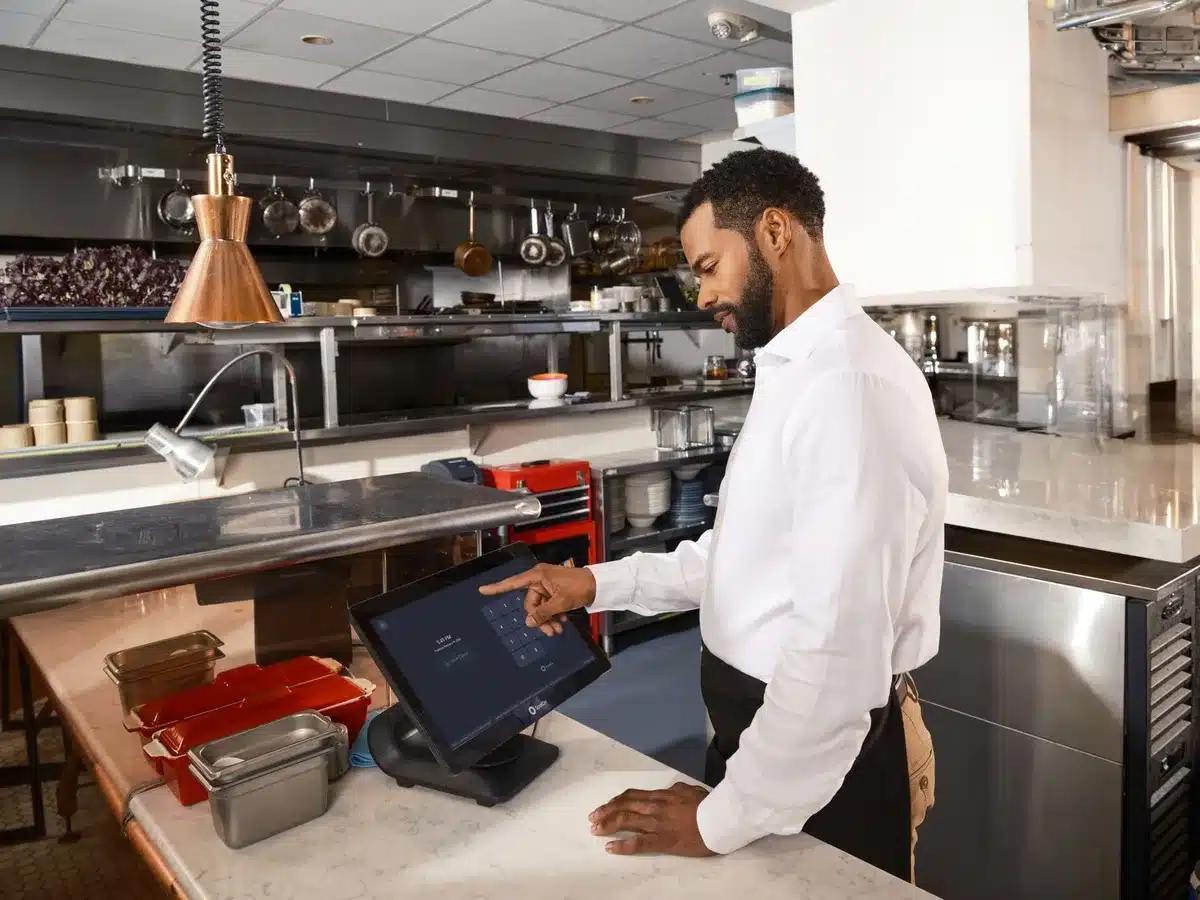 Personal de restaurante procesando operaciones manuales con caja registradora