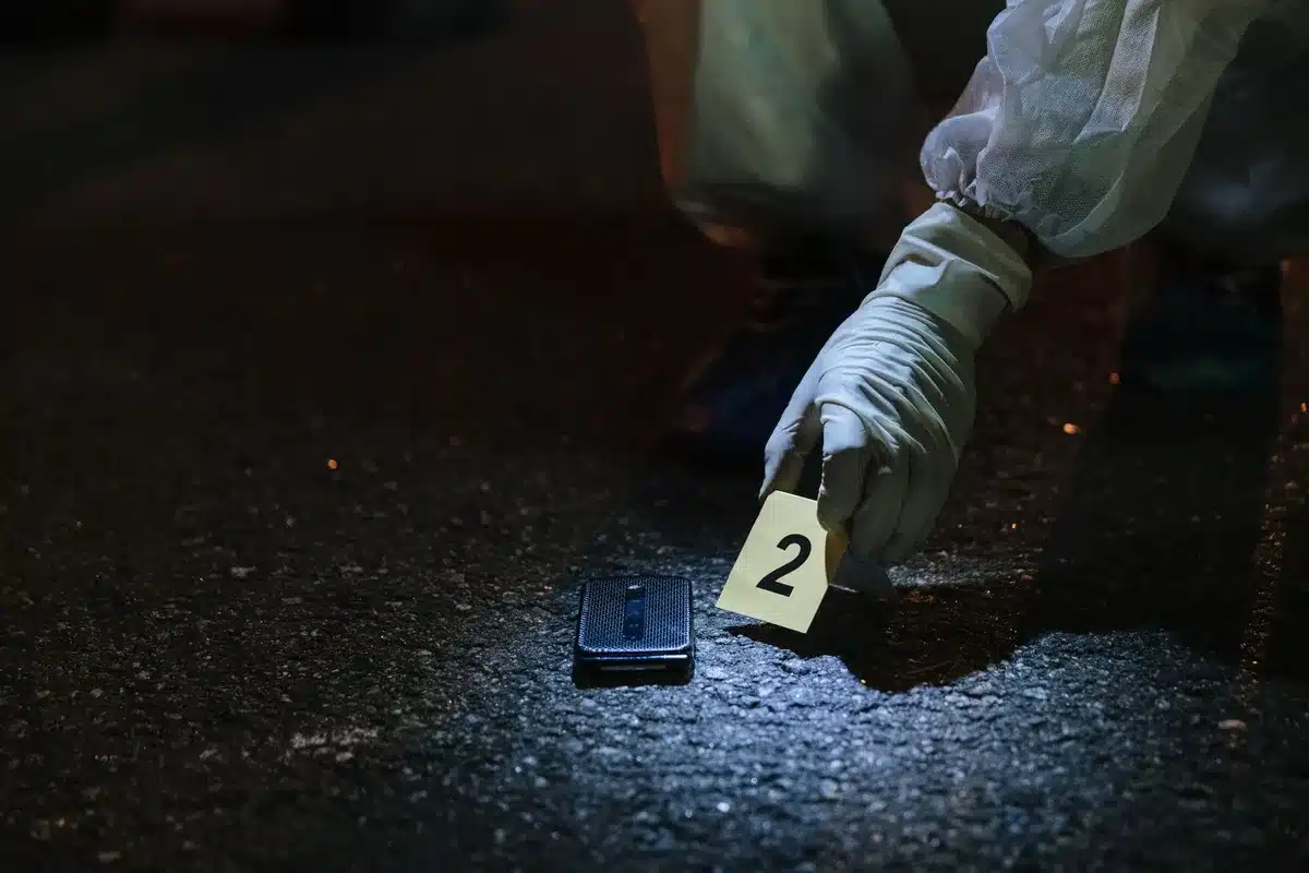 Perito forense analizando un teléfono móvil en laboratorio, representando el análisis de cadena de custodia.