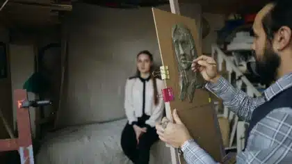 Manos de restaurador trabajando en conservación de obra pictórica histórica