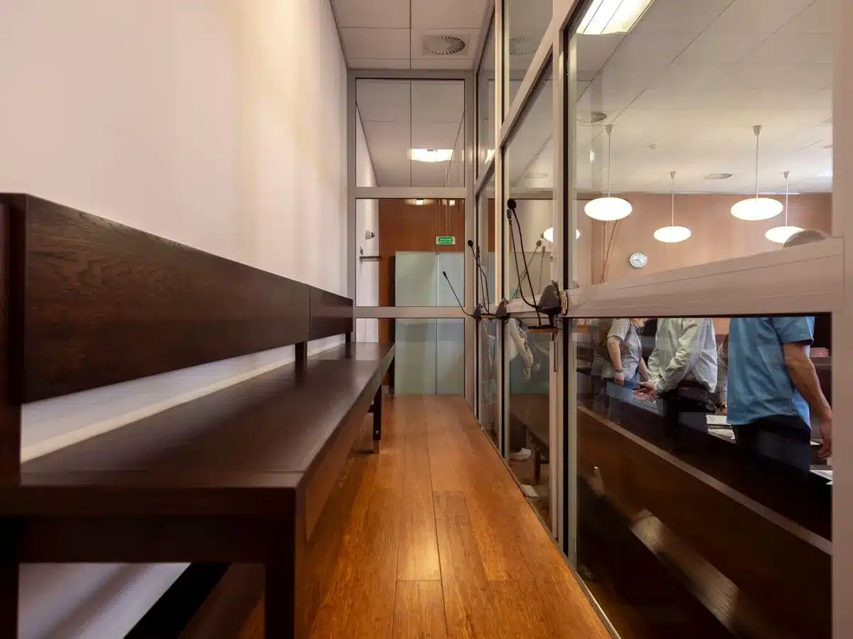 Sala de justicia con magistrados en sus esca&ntilde;os durante una vista judicial formal.