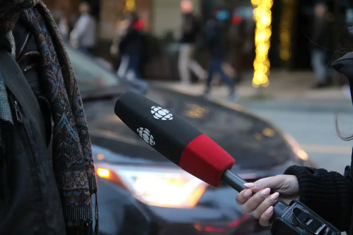 Periodista entrevistando a personas en la calle con micrófono