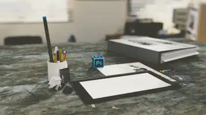 Escritorio de redacción con documentos financieros y titulares de prensa bajo luz matutina