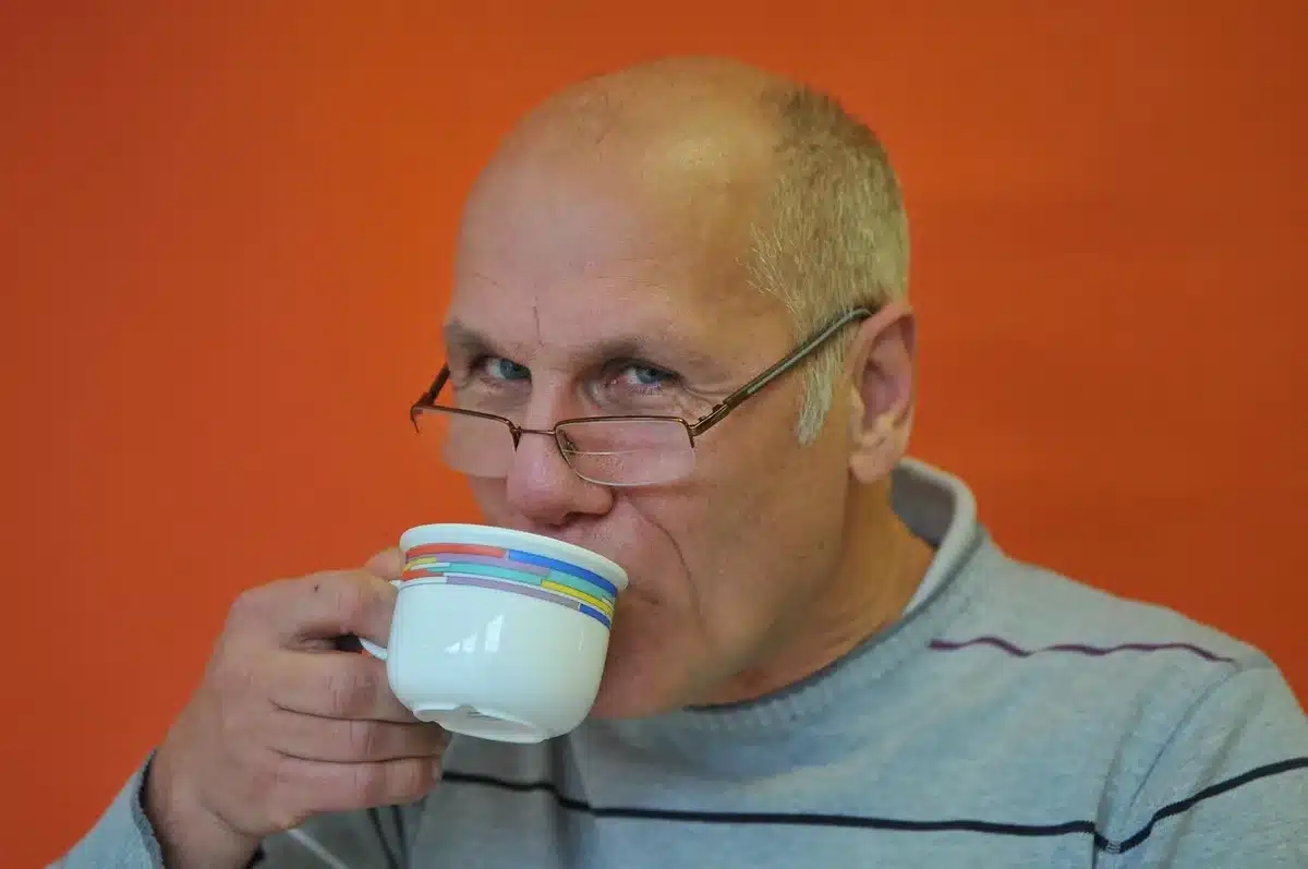 Manos hojeando un periódico con una viñeta en una mesa de redacción