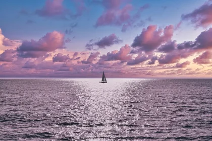 Botes anónimos en la costa al atardecer, manos sujetando una cuerda