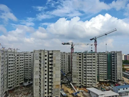 Vista aérea de desarrollo urbanístico con grúas de construcción y edificios en construcción en terrenos vacíos