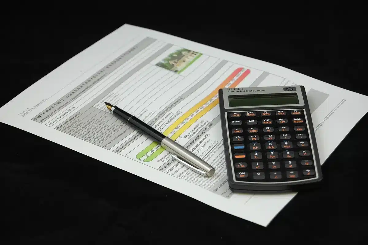 Documentos hipotecarios y calculadora sobre escritorio con gráficos de aumento de costos