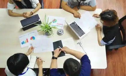 Manos sobre documentos fiscales en una mesa de despacho, ambiente tenso