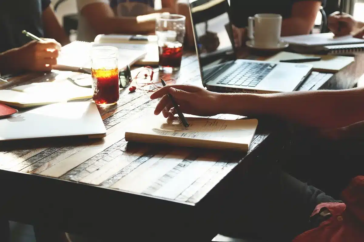 Reunión de equipo pequeño en oficina analizando datos de mercados internacionales en pantalla