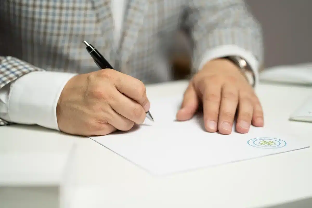 Documentos oficiales y sobres cerrados sobre el escritorio de un juzgado con pantalla de ordenador