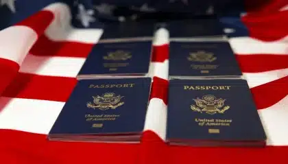 Manos sobre papeles y pasaportes en una mesa de oficina administrativa