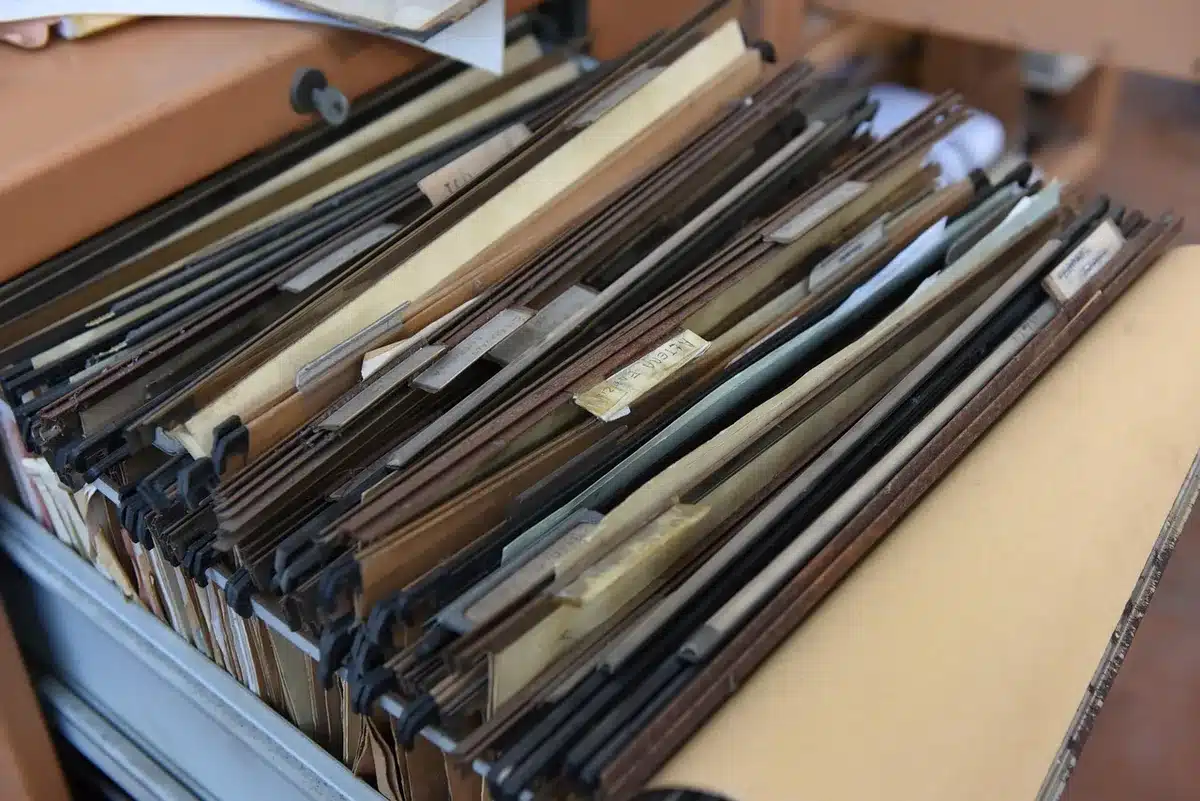Documentos de nómina y papeles administrativos sobre un escritorio, con reloj de fondo