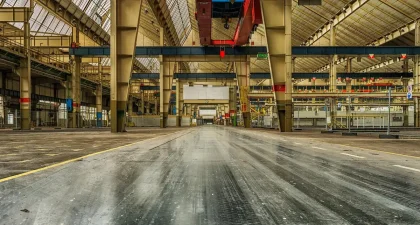 Línea de producción automotriz con maquinaria parada y estaciones vacías.