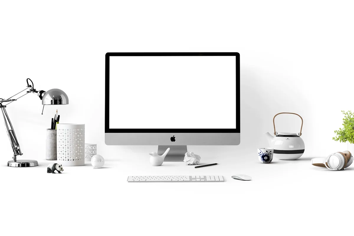 Mesa de redacción con monitor que muestra código HTML y manos tecleando