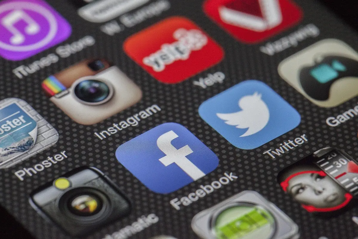 Persona mirando redes sociales en un móvil con publicaciones sobre convocatorias
