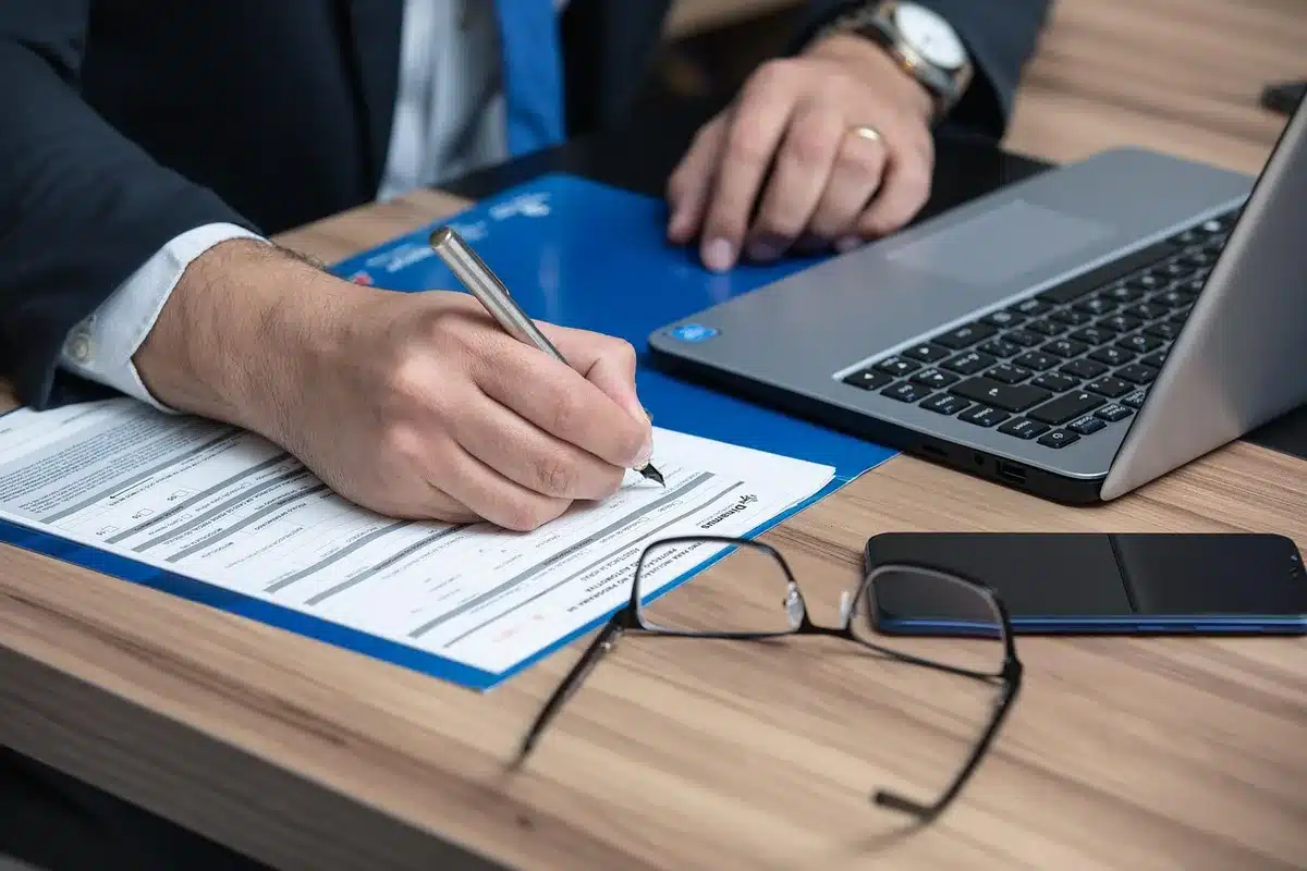 Persona escaneando documentos y organizando archivos digitales en un portátil