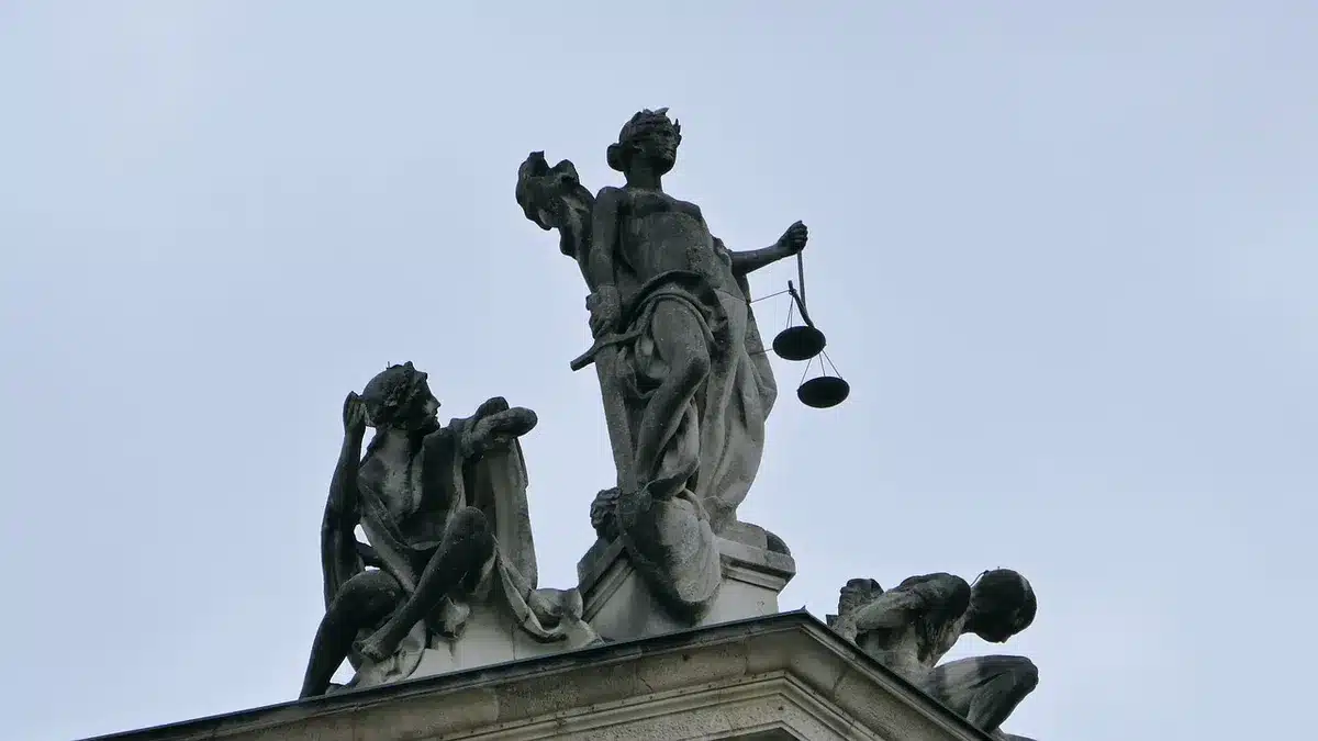 Balanza de la justicia junto a una urna de votación simbólica
