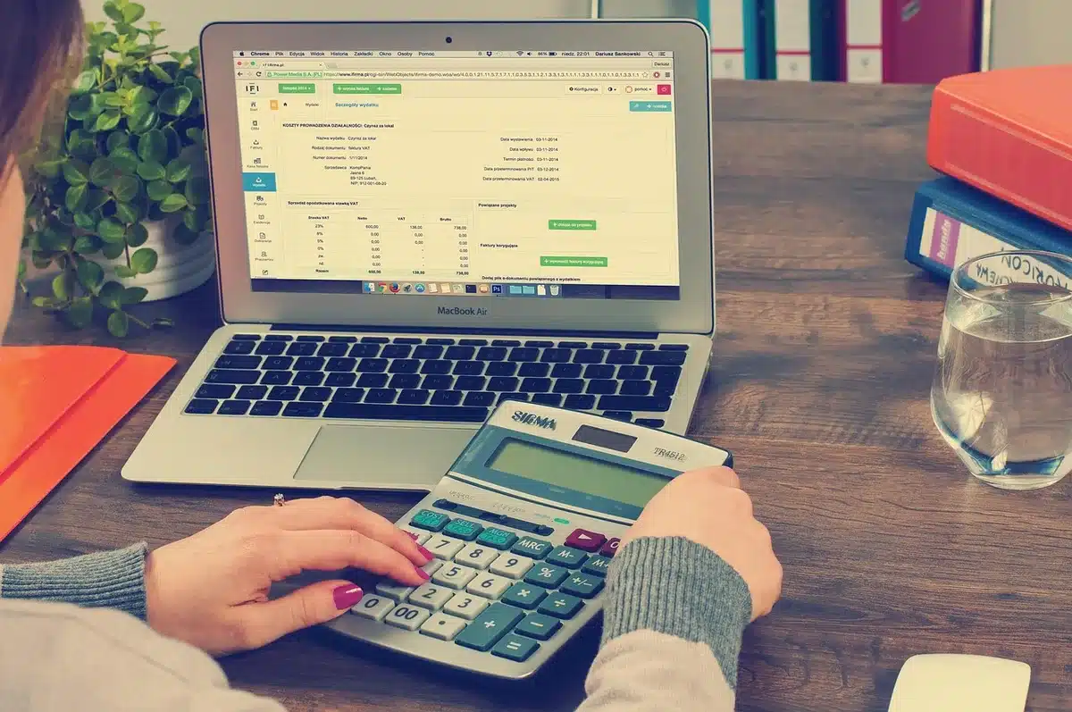Manos sobre calculadora y facturas en una mesa familiar