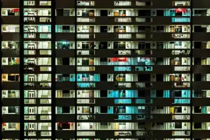 Pasillo de bloque residencial con cajas y ropa tendida, luz diurna
