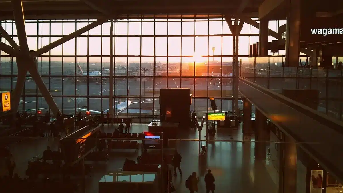 Pantalla de salidas y puerta vacía en aeropuerto