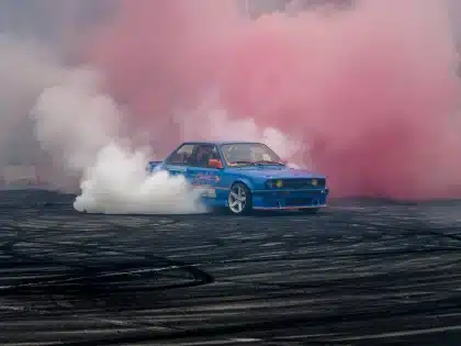 Dos motos en curva sobre asfalto recién reasfaltado, enfoque en neumáticos y manos en el manillar
