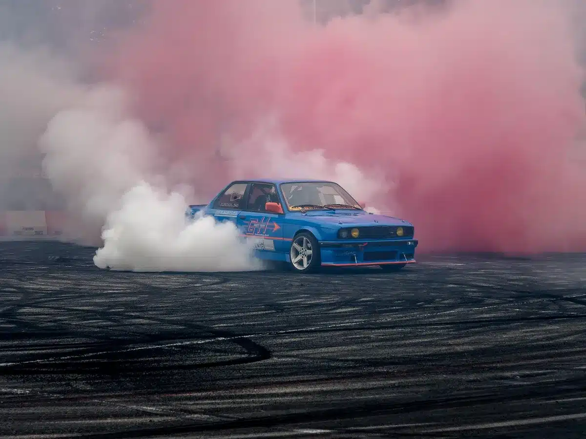 Dos motos en curva sobre asfalto recién reasfaltado, enfoque en neumáticos y manos en el manillar