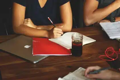 Editor revisando una página de noticias en un portátil con notas al lado en una oficina