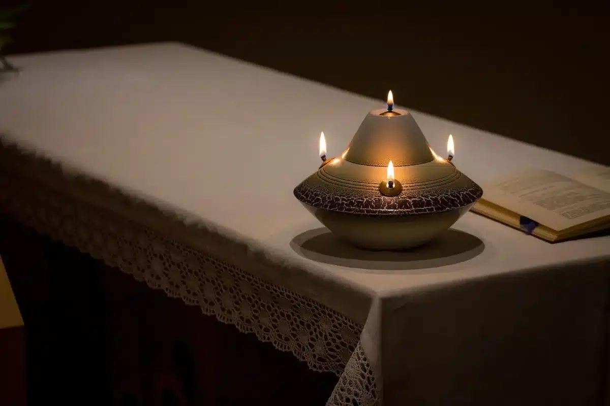 Altar improvisado con velas y coronas frente a un edificio residencial