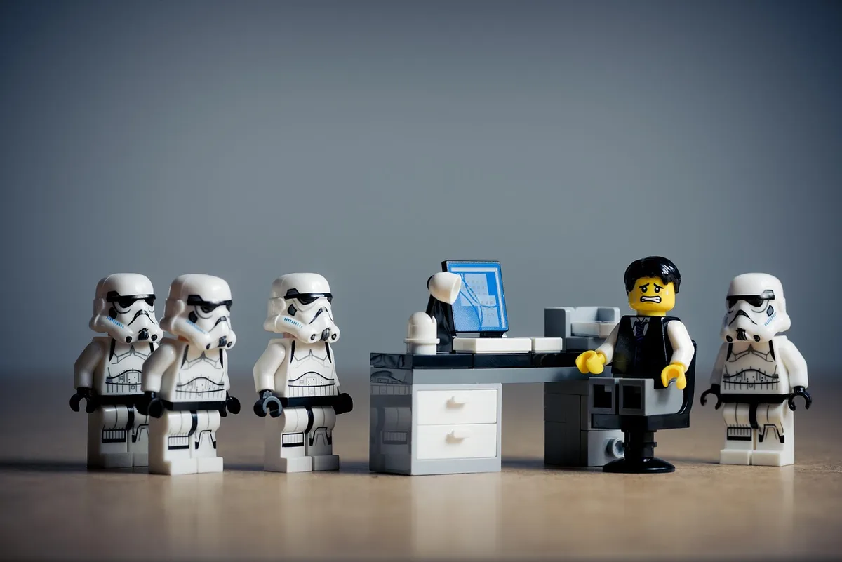 Empleados en un pasillo de oficina conversando preocupados